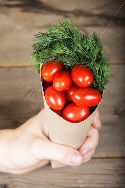 Hand and paper cornet with tomatoes – Stock photos from around the world