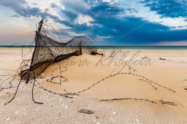 Littered shore of the Caspian Sea under beautiful sunset sky – Stock photos from around the world